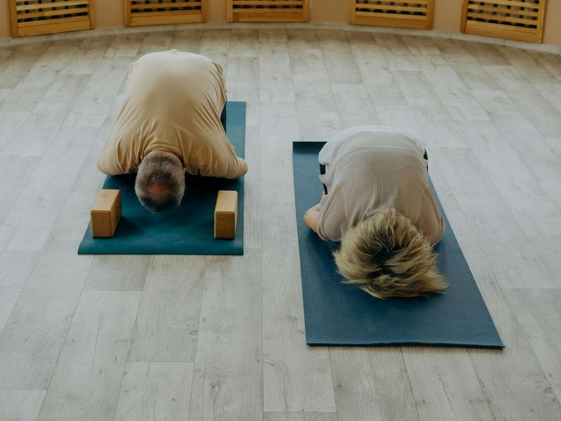 Person practicing yoga in a spacious, well-lit studio.